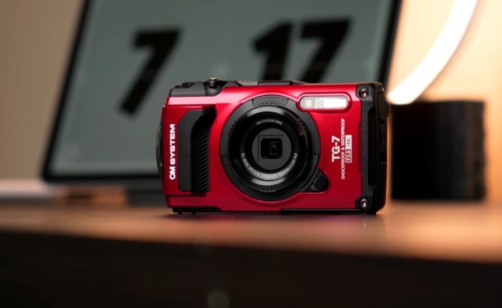 Un appareil photo rouge contre un fond flou avec une lampe