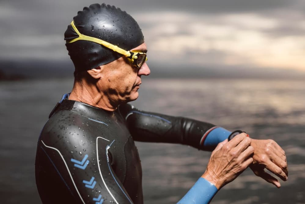 Un nageur en combinaison ajuste ses lunettes dans l'océan